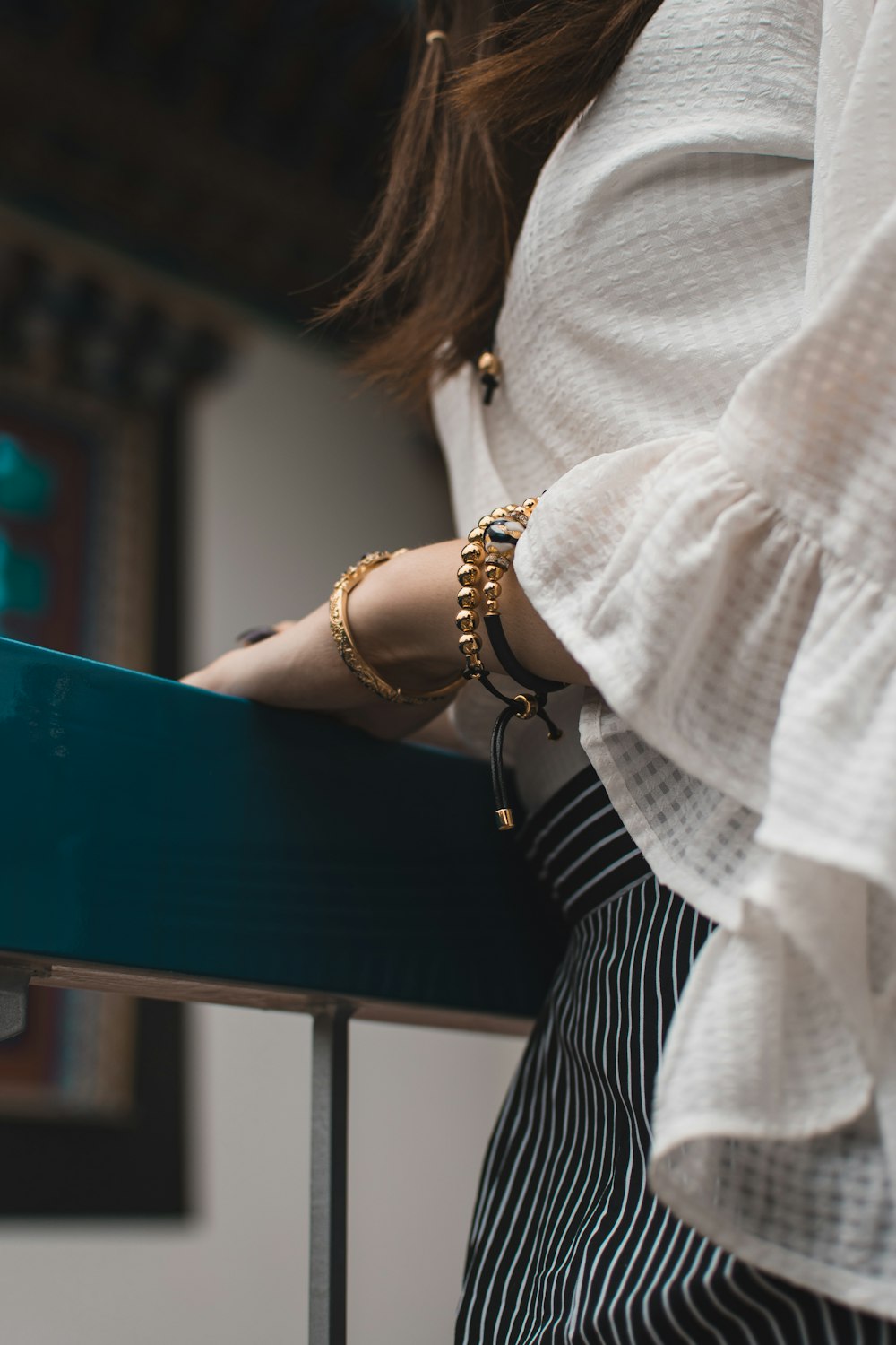 mujer con top blanco y pulseras de color dorado