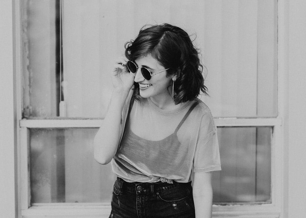 grayscale photography of woman near window