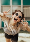 selective focus photography of jolly woman using peace hand gesture