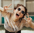 selective focus photography of jolly woman using peace hand gesture