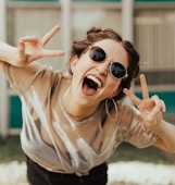 selective focus photography of jolly woman using peace hand gesture