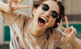 selective focus photography of jolly woman using peace hand gesture