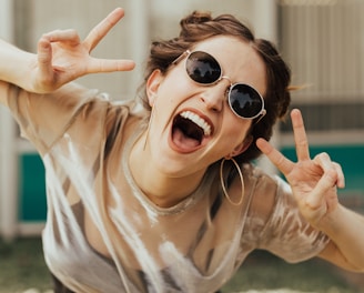 selective focus photography of jolly woman using peace hand gesture