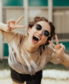 selective focus photography of jolly woman using peace hand gesture