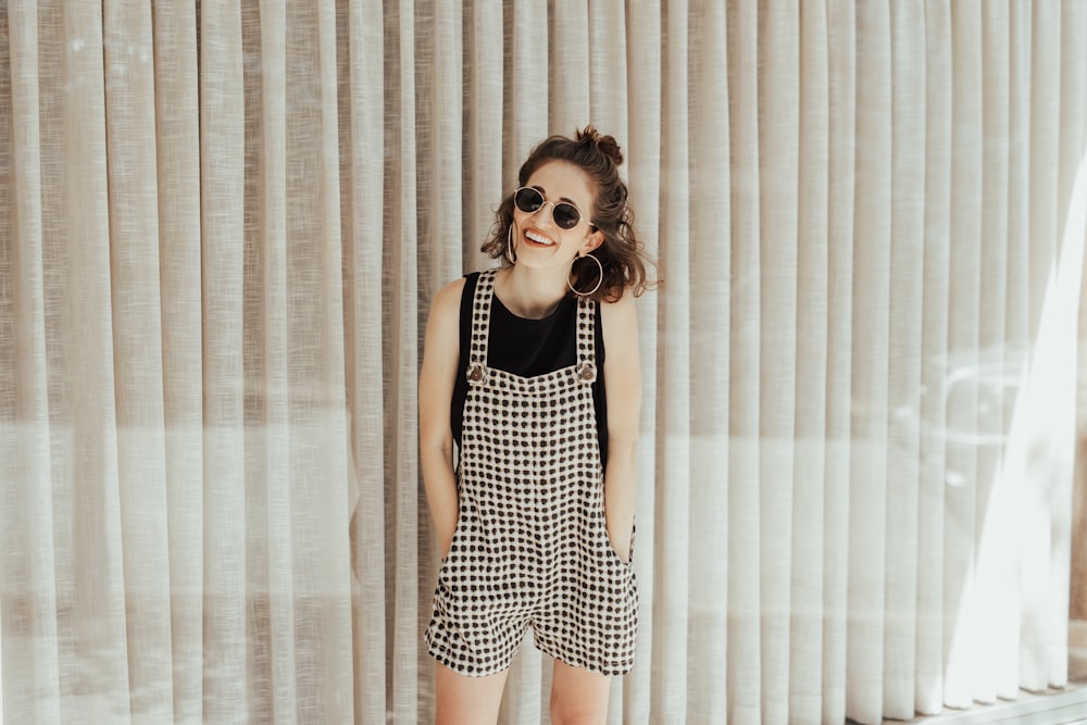 woman smiling while standing near curtain