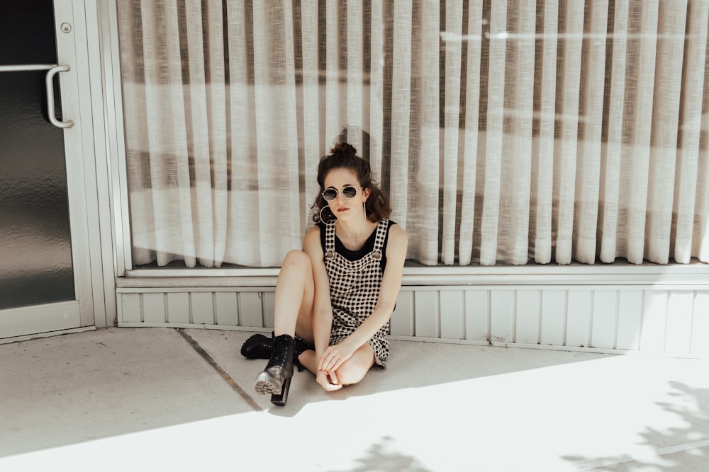 woman sitting while leaning on window wall