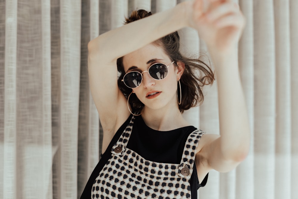 woman in black tank top near curtain