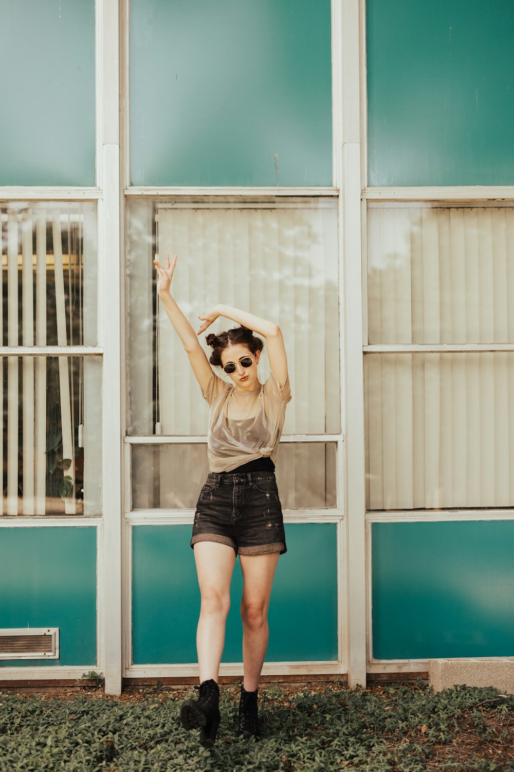 woman standing beside blue house