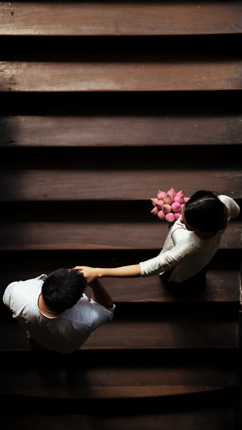 Pasangan pengantin bergandengan tangan menuruni tangga