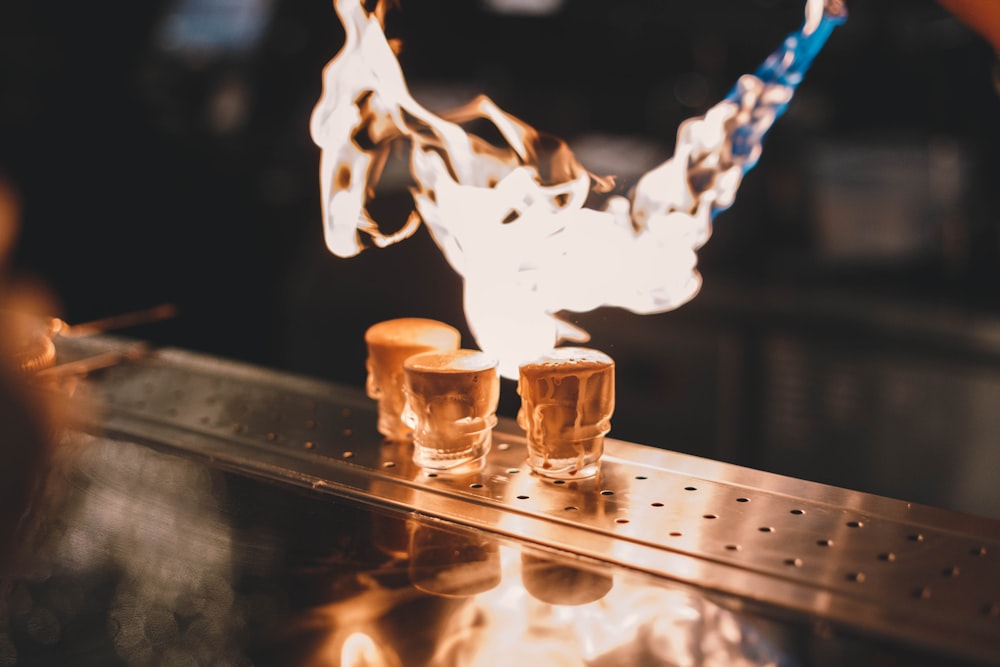 a person pouring liquid into glasses on top of a counter