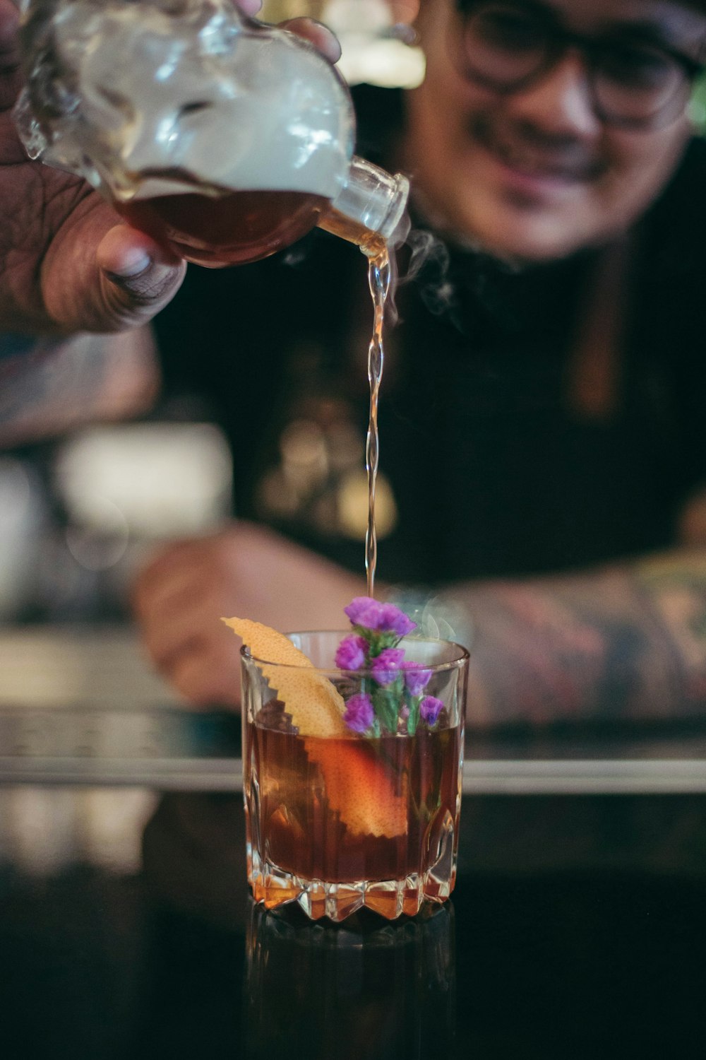 man pouring liquid in glass