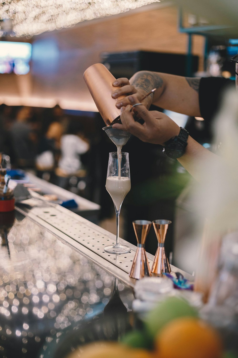 person put white liquid on champagne glass