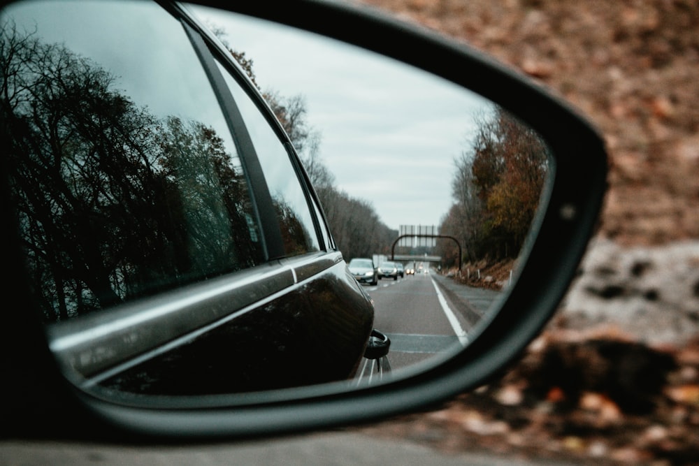 reflection of cars on asphalt road in side view mirror