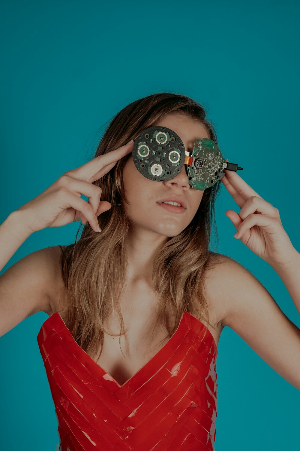 woman covering her eyes with circuit boards