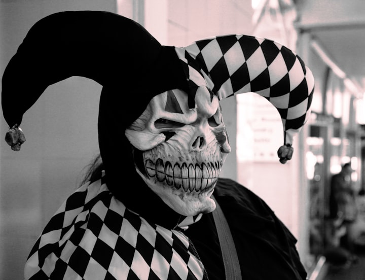 A monochrome jester in a skull mask