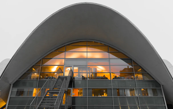 Modern architectural office entrance with warm lighting at dusk.