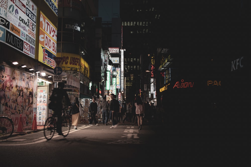 a man riding a bike down a street at night