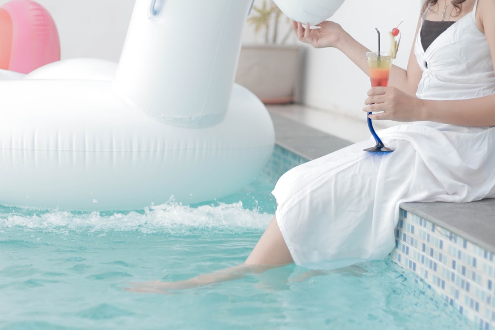 woman sitting beside the pool