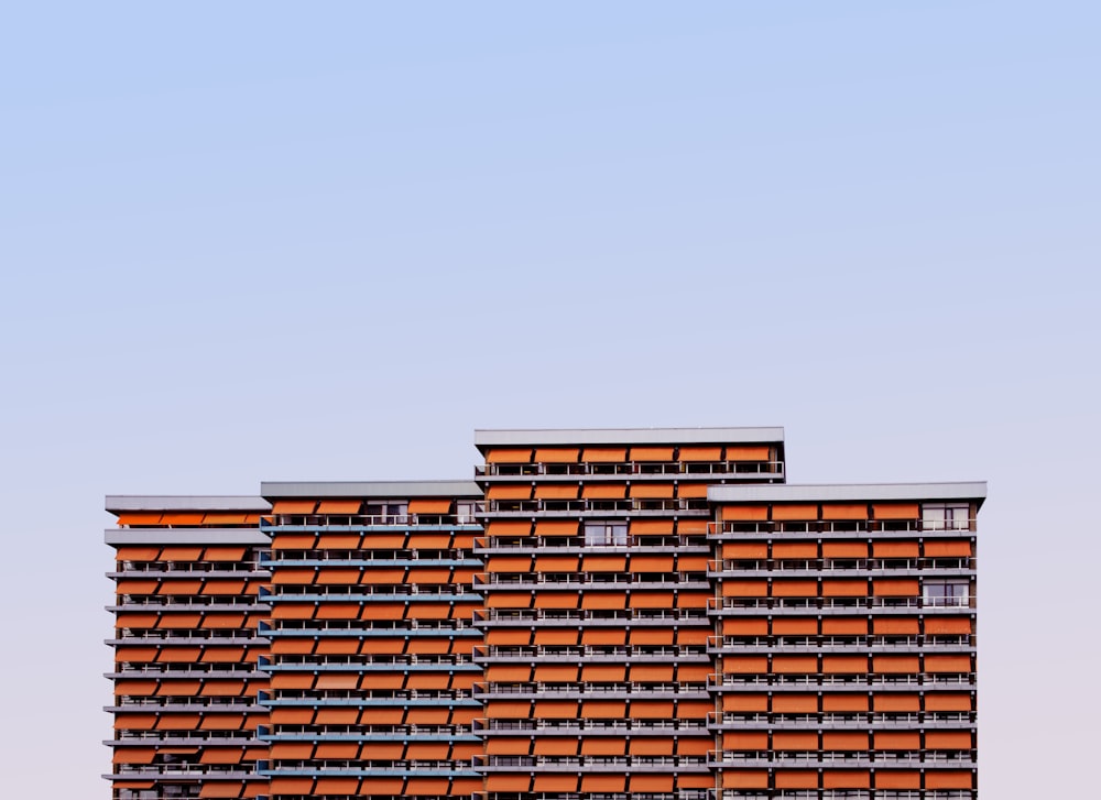 Immeuble de grande hauteur orange et blanc sous un ciel bleu pendant la journée