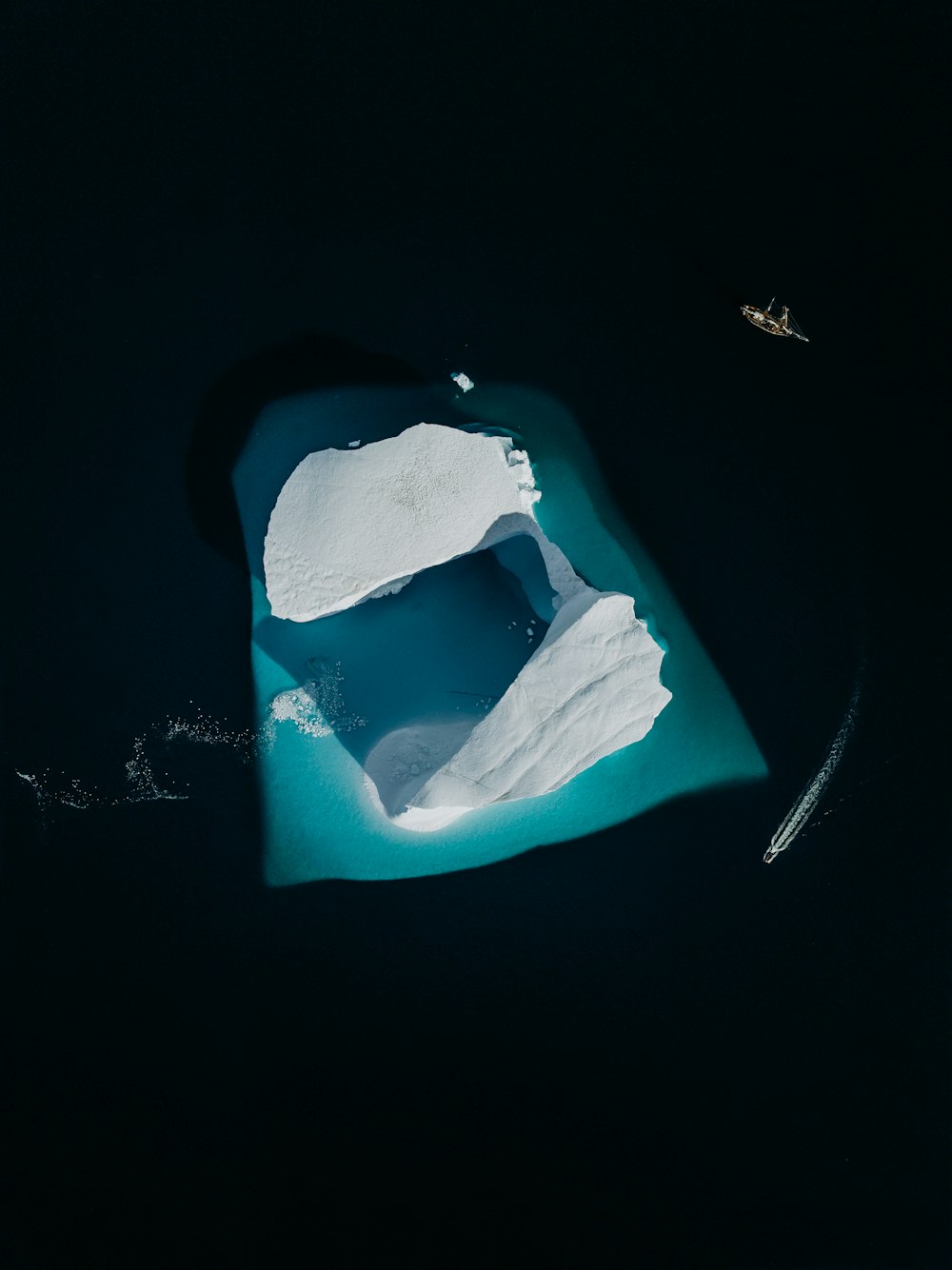 an aerial view of an iceberg in the water