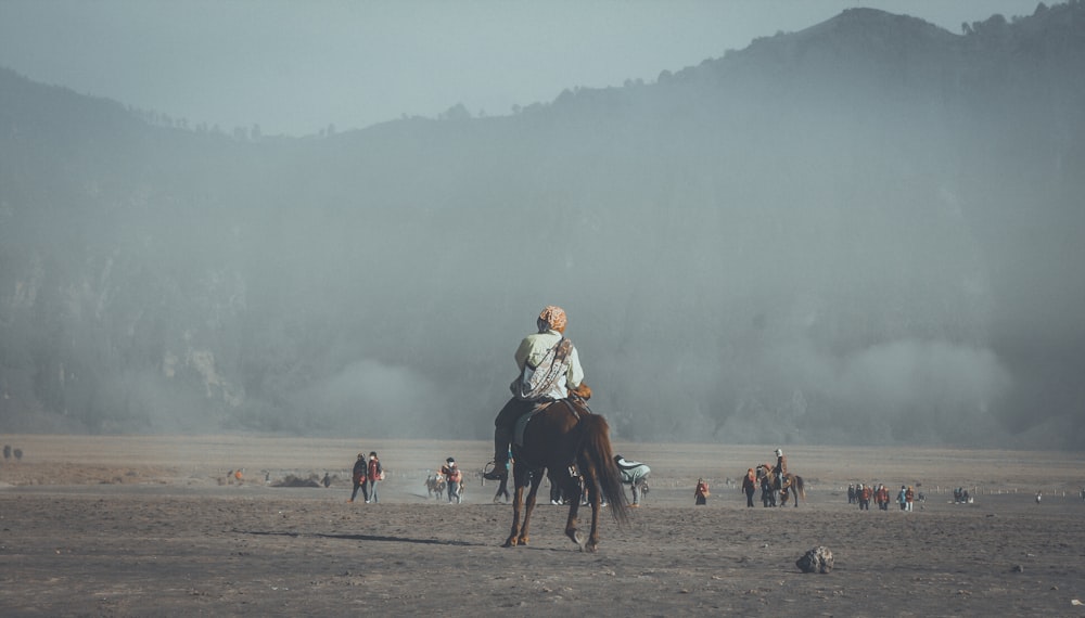 man riding horse far away from mountains