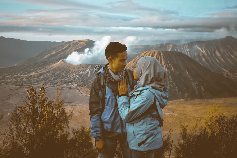 man and woman standing face to face near volcano during daytime