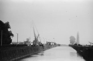 grayscale photography of body of water near buildings