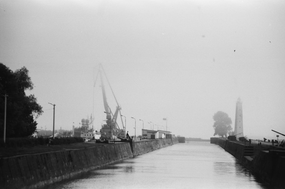 grayscale photography of body of water near buildings