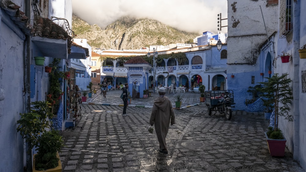 people walking on street in between concrete buildings during daytime