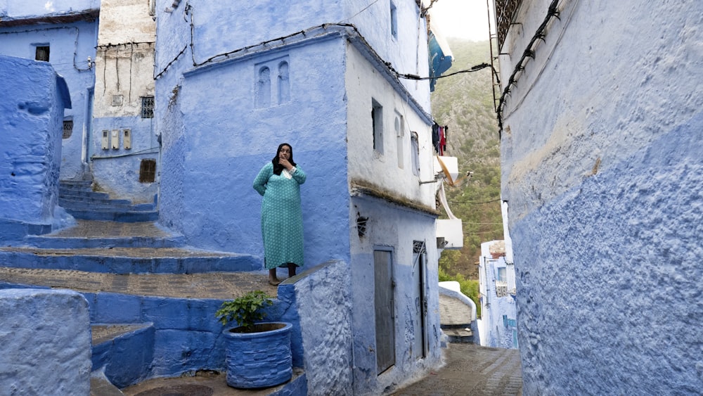 woman standing on stairs beside blue building