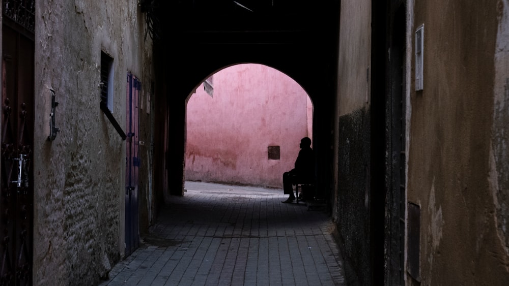 person sitting at the end of the alley