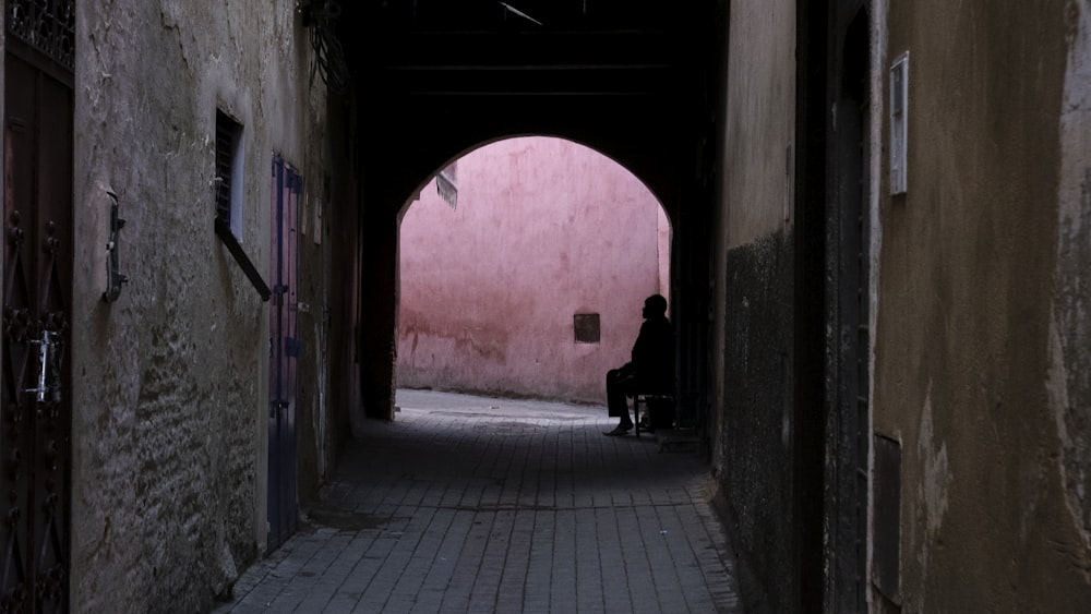 person sitting at the end of the alley