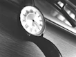 A high-contrast image of a luxury watch and sleek sunglasses arranged on a white marble background.