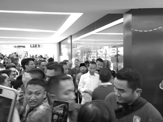 A candid shot of a bustling press event, capturing the energy and anticipation in the room.