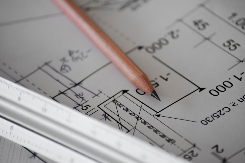A close-up of skilled hands carefully measuring blueprints on a construction site.