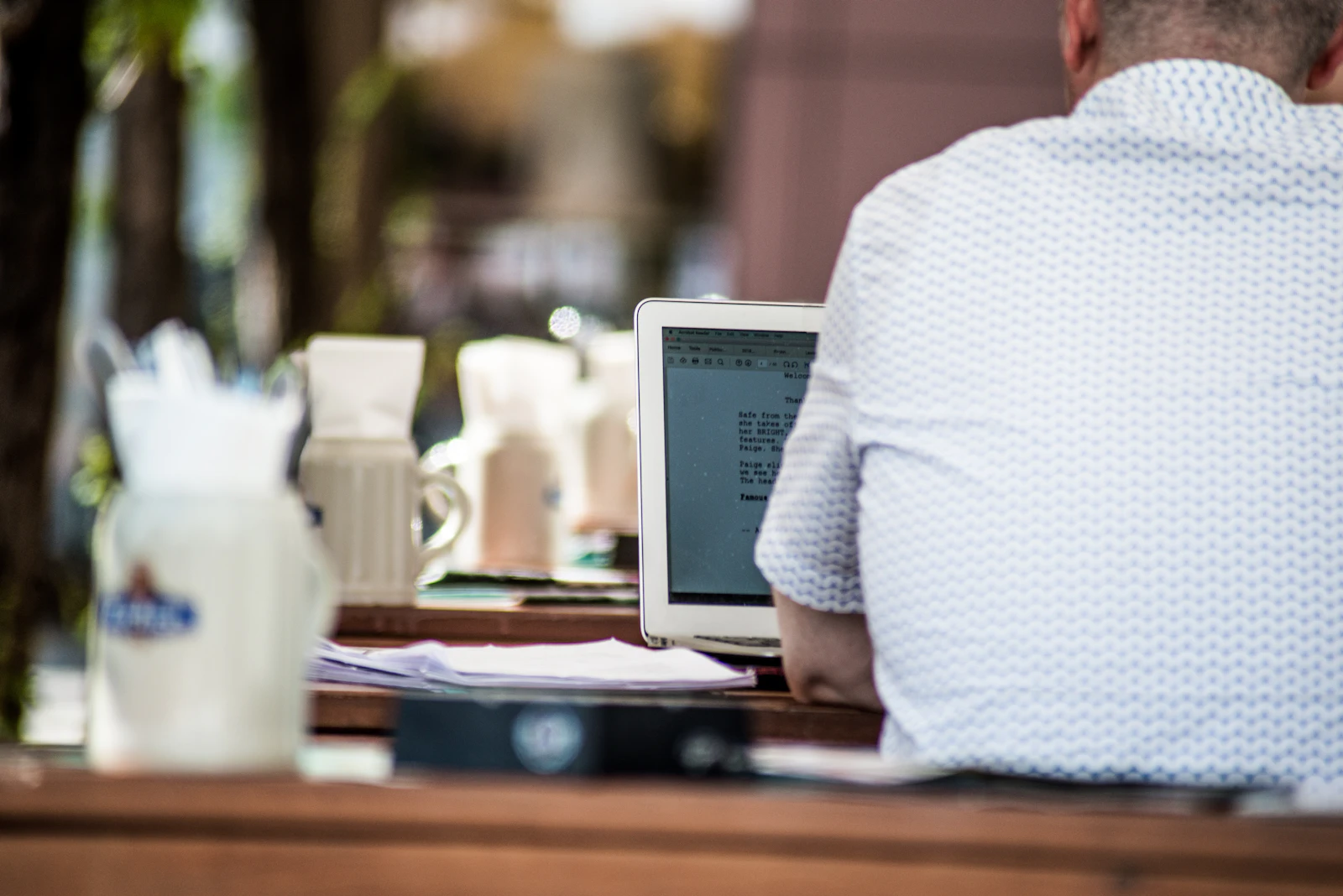 Person working on a laptop at an outdoor cafe table