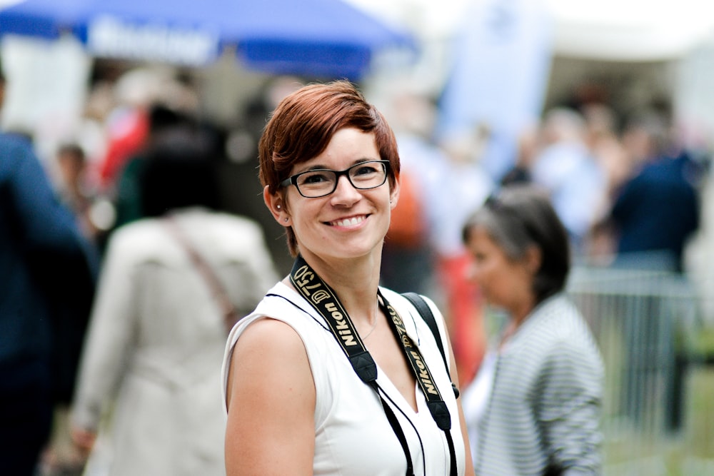 standing woman while smiling near crowd during daytime