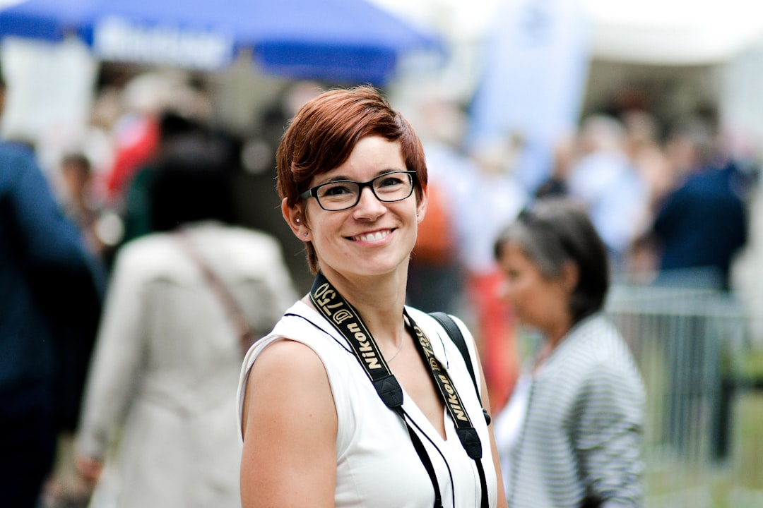 standing woman while smiling near crowd during daytime