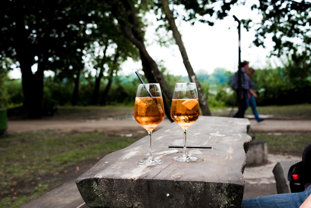 two wine glasses filled with substance on table