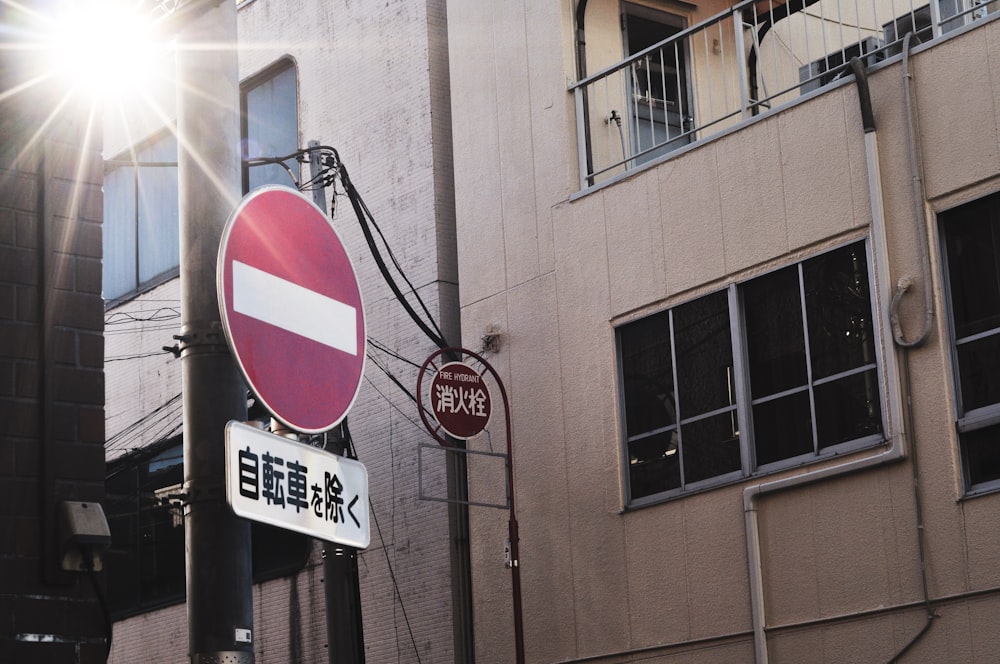 a red and white street sign sitting next to a tall building