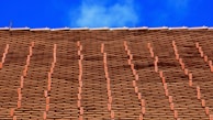 Wide shot of a residential home featuring a newly tiled roof with neat, uniform rows.