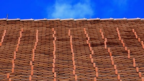 Side view of a house featuring a classic tile roof with neat, even rows