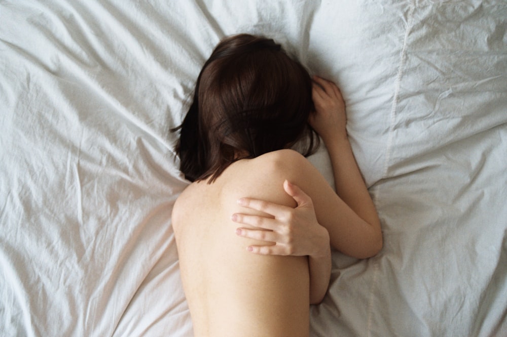 woman lying on white bed