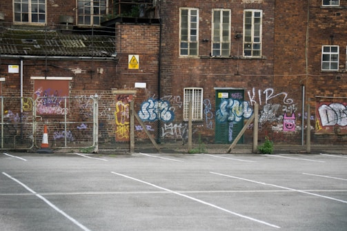 Aerial view of an urban vacant lot with artistic installations and graffiti.