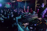 people inside building at night dancing to DJ