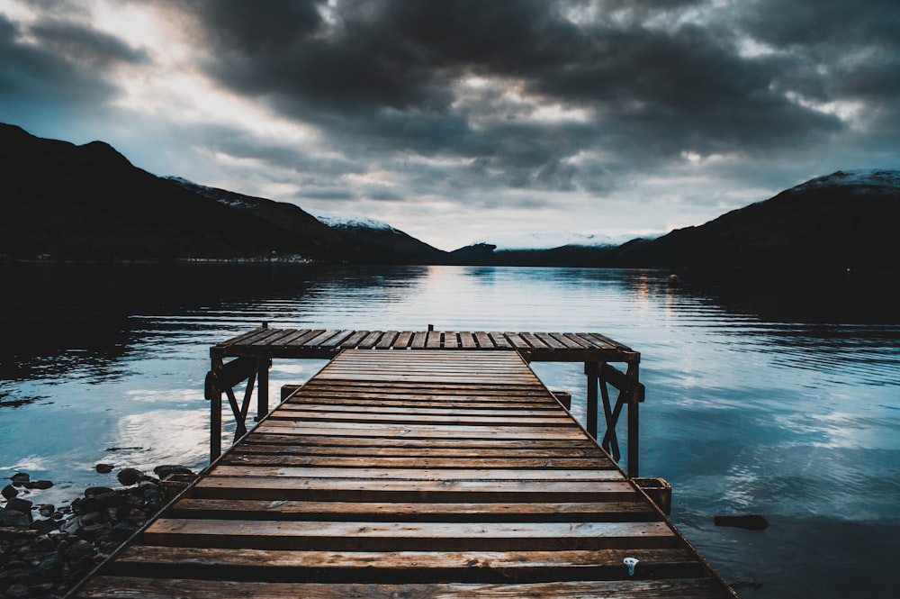 brown wooden dock near mountains