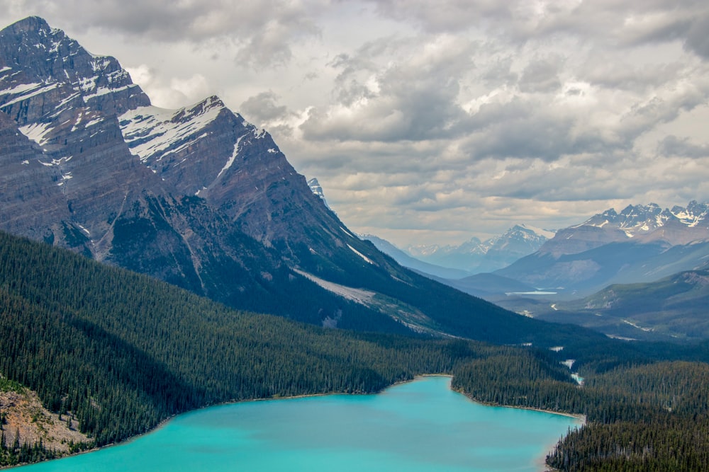 Montaña verde y blanca cerca del cuerpo de agua durante el día