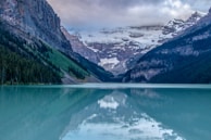 A serene lake surrounded by mountains and wildlife.