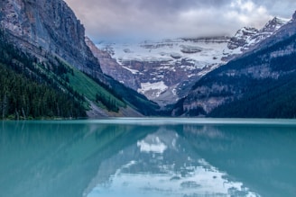 A serene lake surrounded by mountains and wildlife.