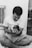 a man sitting on a bed holding a baby